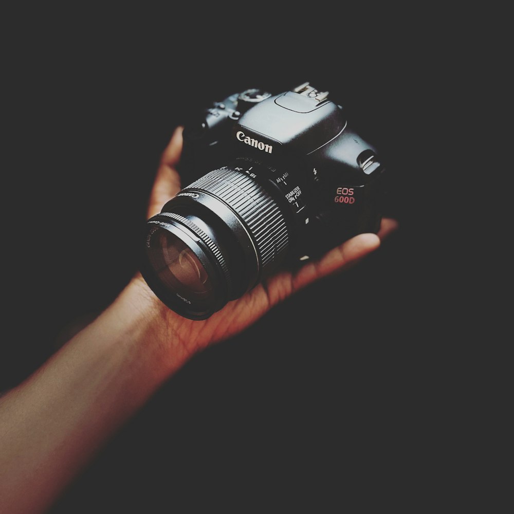 person holding black nikon dslr camera