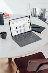 black laptop computer on white round table