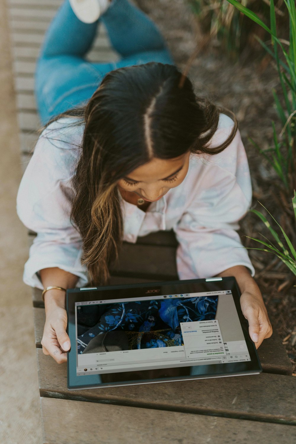 woman in white long sleeve shirt holding laptop