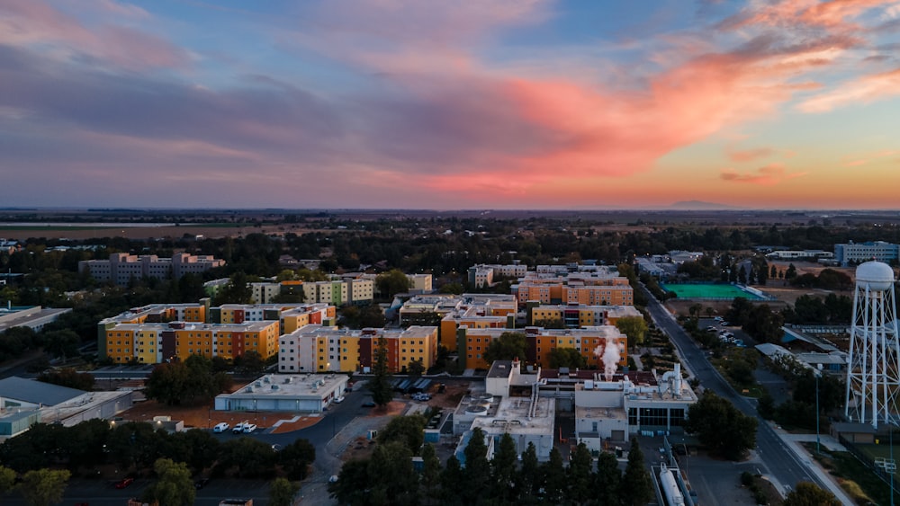 city with high rise buildings under orange and gray skies