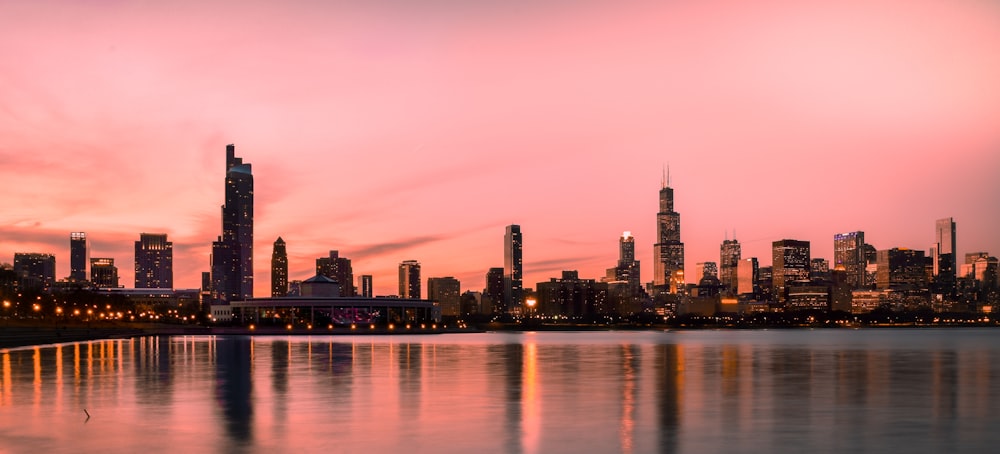 skyline della città attraverso lo specchio d'acqua durante il tramonto