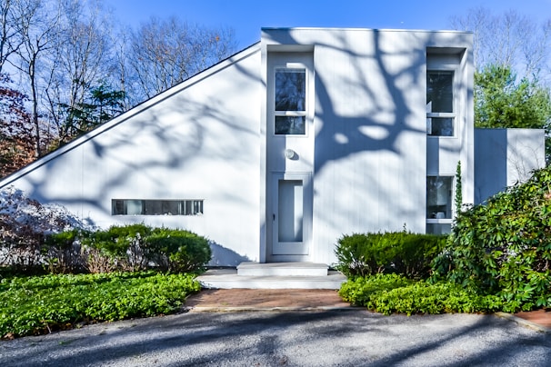 white concrete house near green trees during daytime