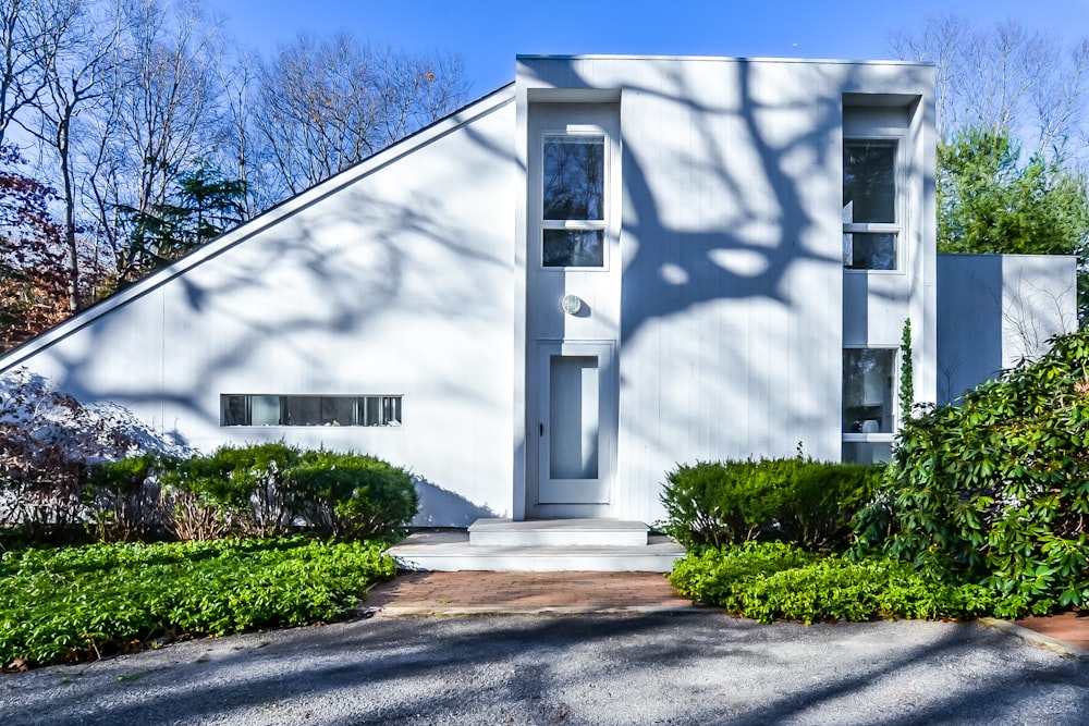 white concrete house near green trees during daytime