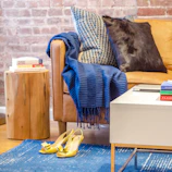 A styled living room corner featuring loomara’s rugs, throws, and pillows.