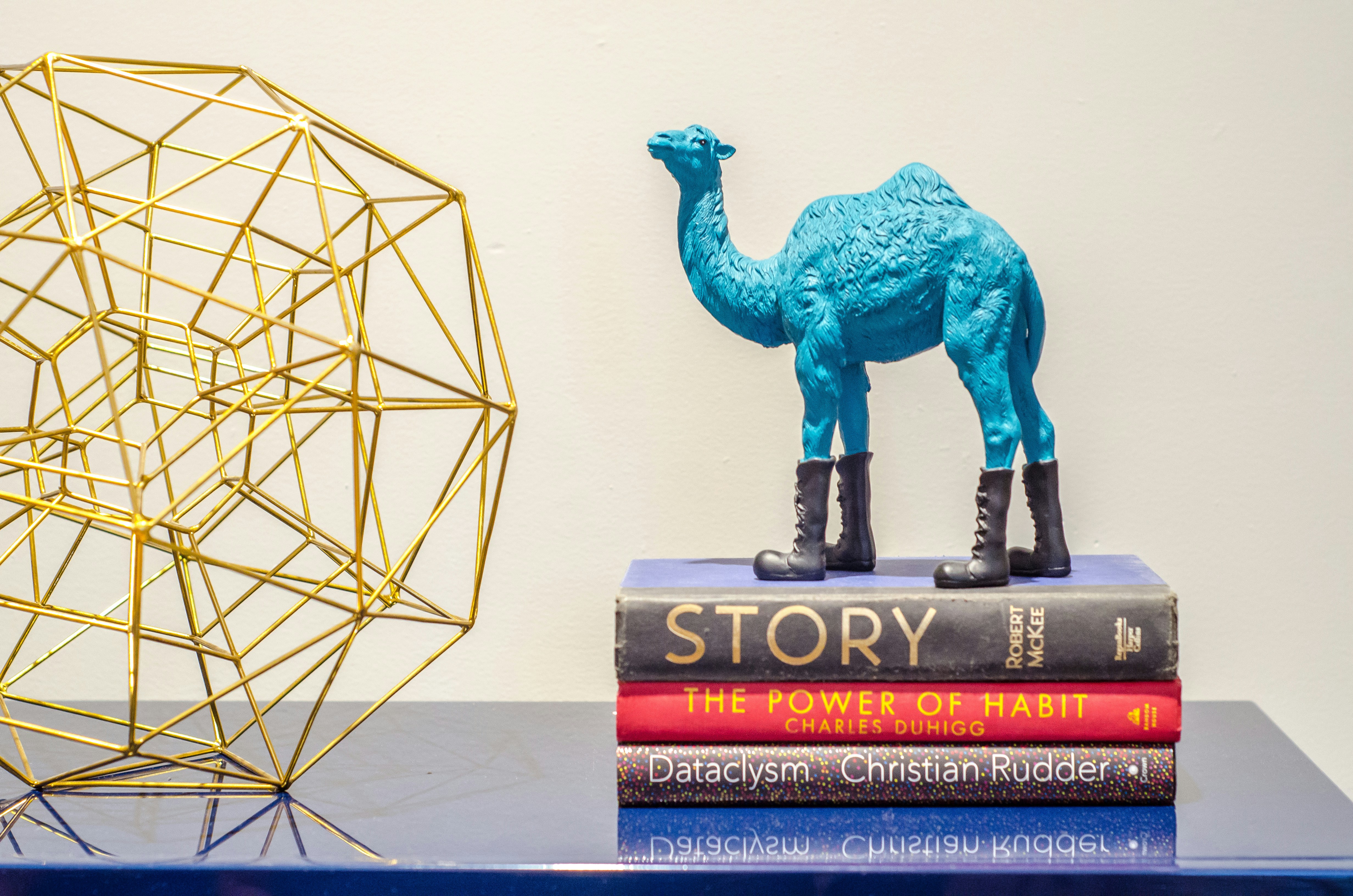 Figurina marrone del dinosauro accanto alla piramide bianca e nera