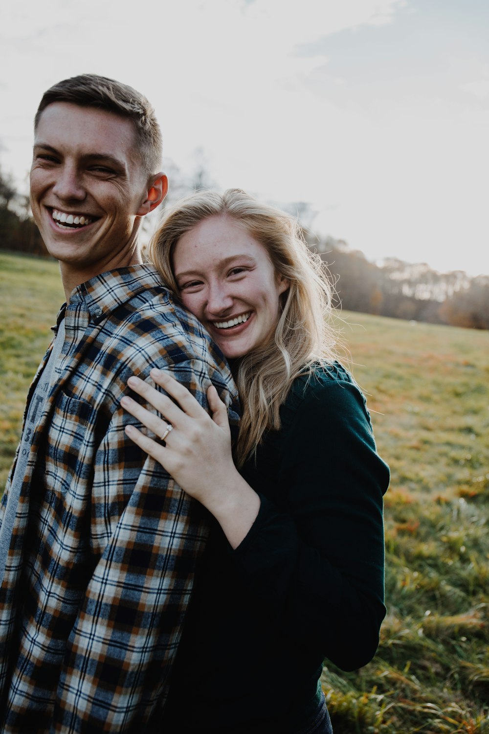 man and woman kissing on green grass field during daytime