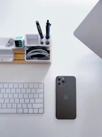 A professional cleaner wiping down a modern office desk with supplies neatly arranged.