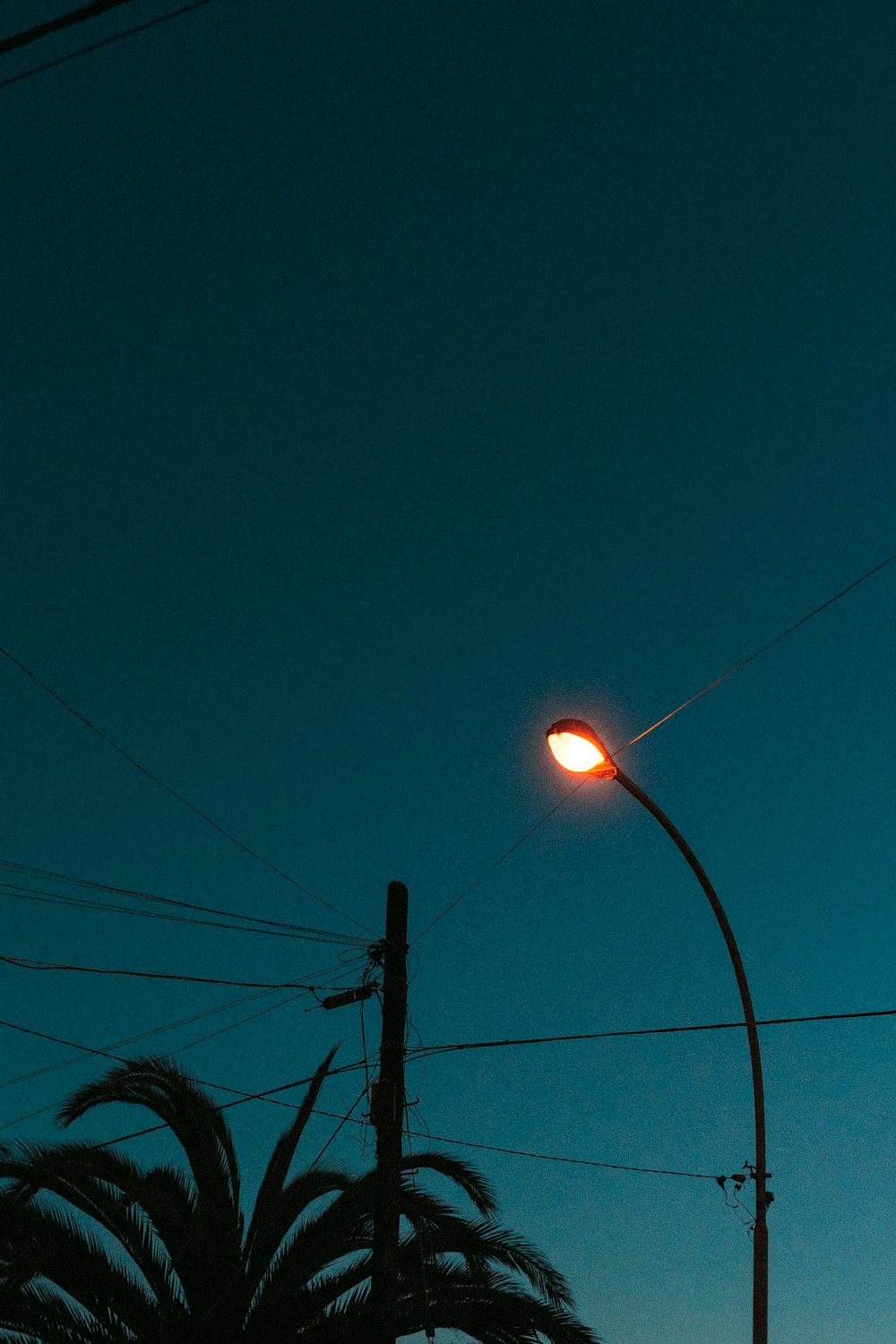 black electric post under blue sky during night time