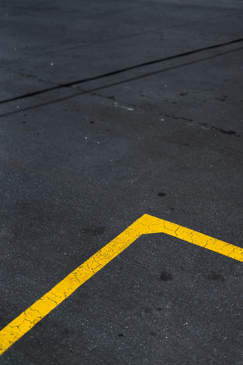 yellow and black arrow sign on gray concrete road