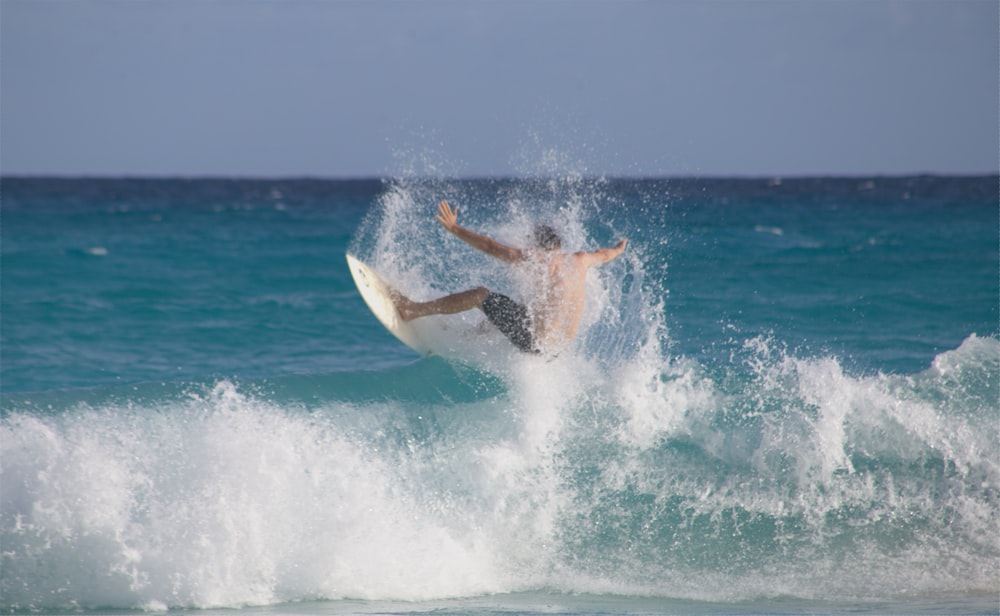 man surfing on sea waves during daytime