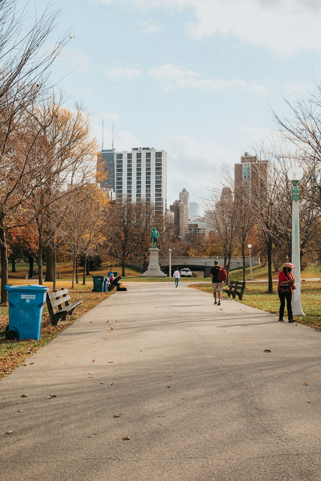 people walking on sidewalk near bare trees during daytime