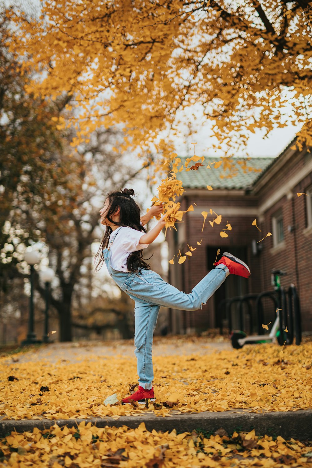 woman in white long sleeve shirt and blue denim jeans holding red and black nike athletic