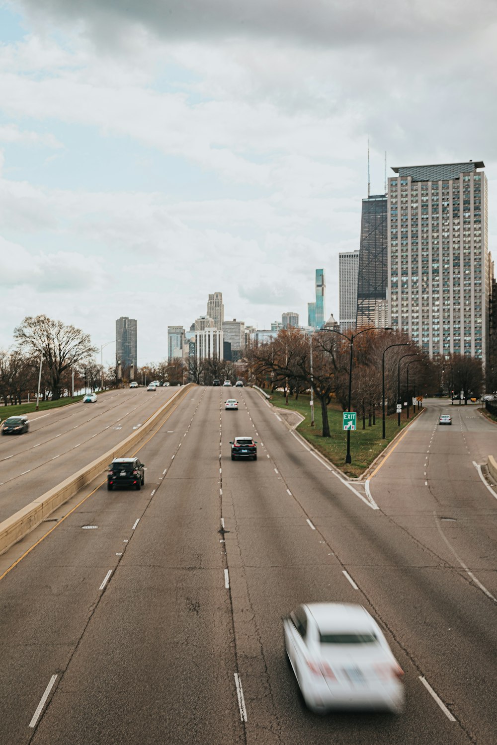 a car driving down a highway next to tall buildings