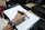 Close-up of hands writing in a sleek financial planner with a golden pen on a black desk.
