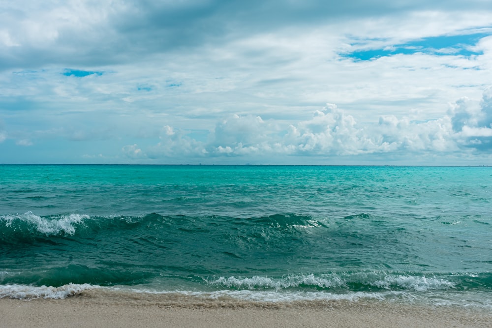 Mer bleue sous ciel bleu et nuages blancs pendant la journée