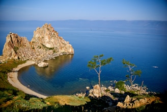 brown rock formation beside blue sea under blue sky during daytime