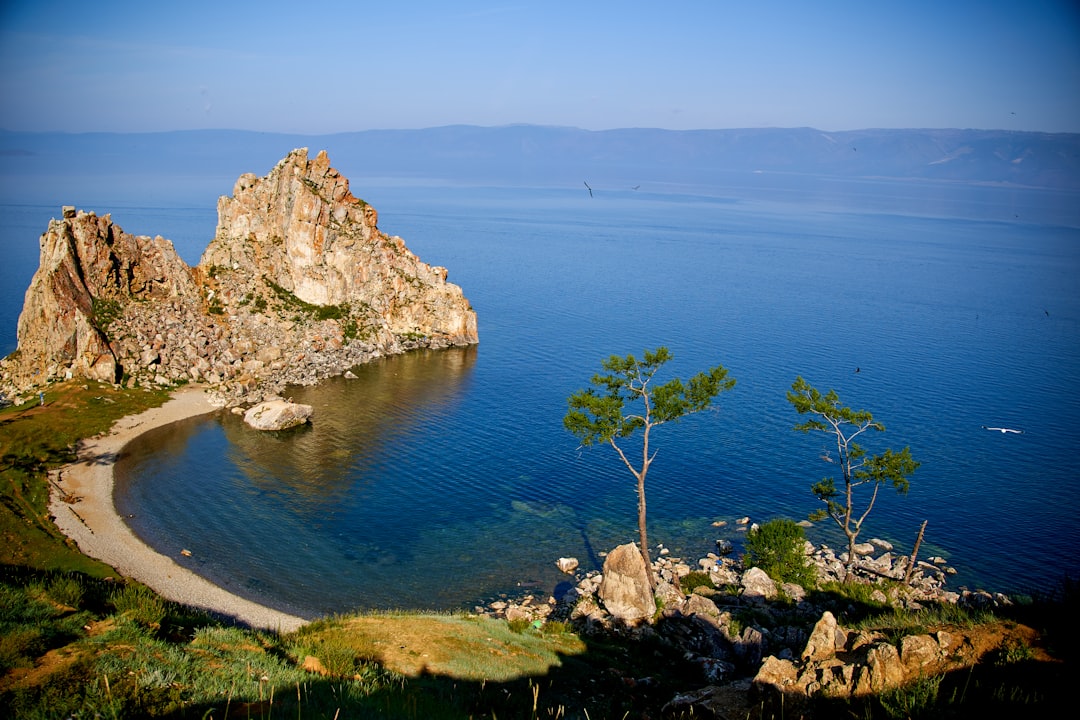 brown rock formation beside blue sea under blue sky during daytime