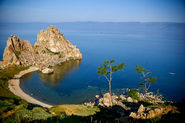 Brown rock formation beside blue sea under blue sky during daytime — Lake Baikal, Russia