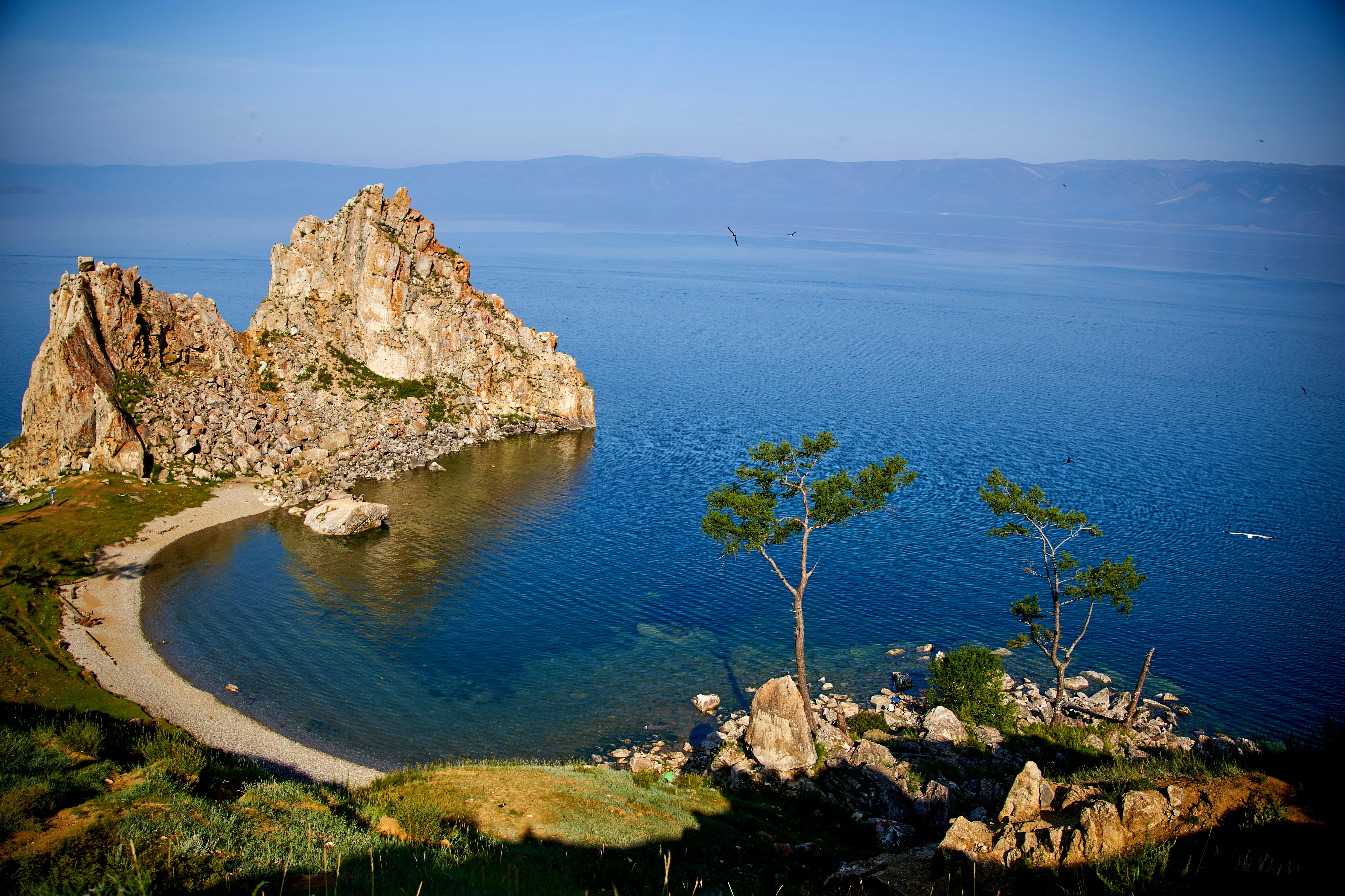 brown rock formation beside blue sea under blue sky during daytime