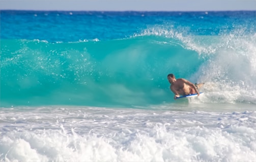 Close-up of a surfboard carving through foamy blue ocean water.