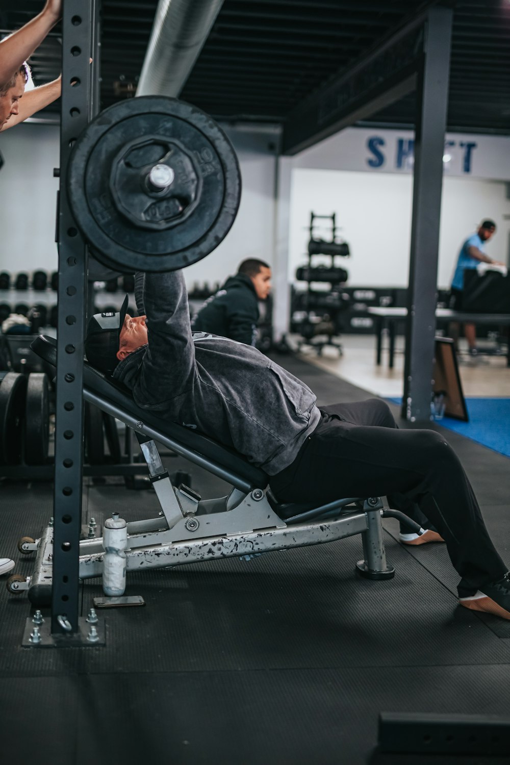 man in black jacket and black pants sitting on black exercise equipment