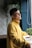 A bright, cheerful person practicing a simple daily habit in a cozy home environment.