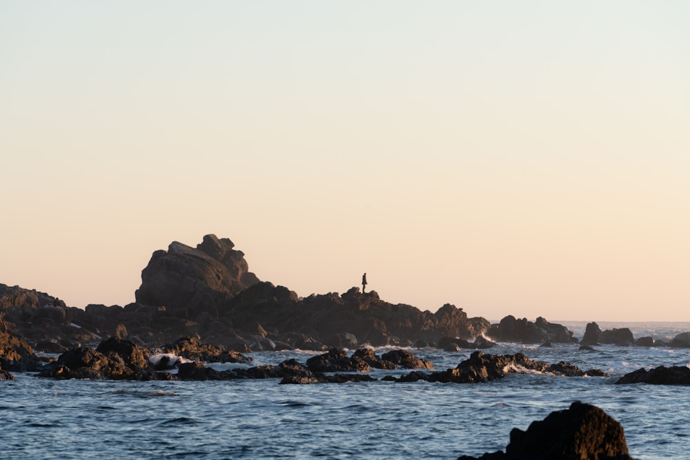 rock formation on sea under white sky during daytime