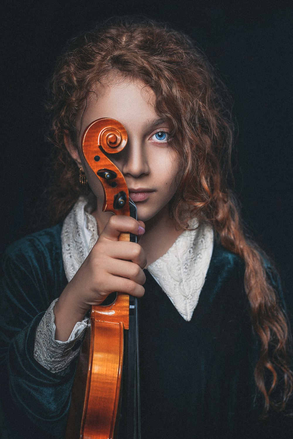 woman in black and white sweater holding brown violin