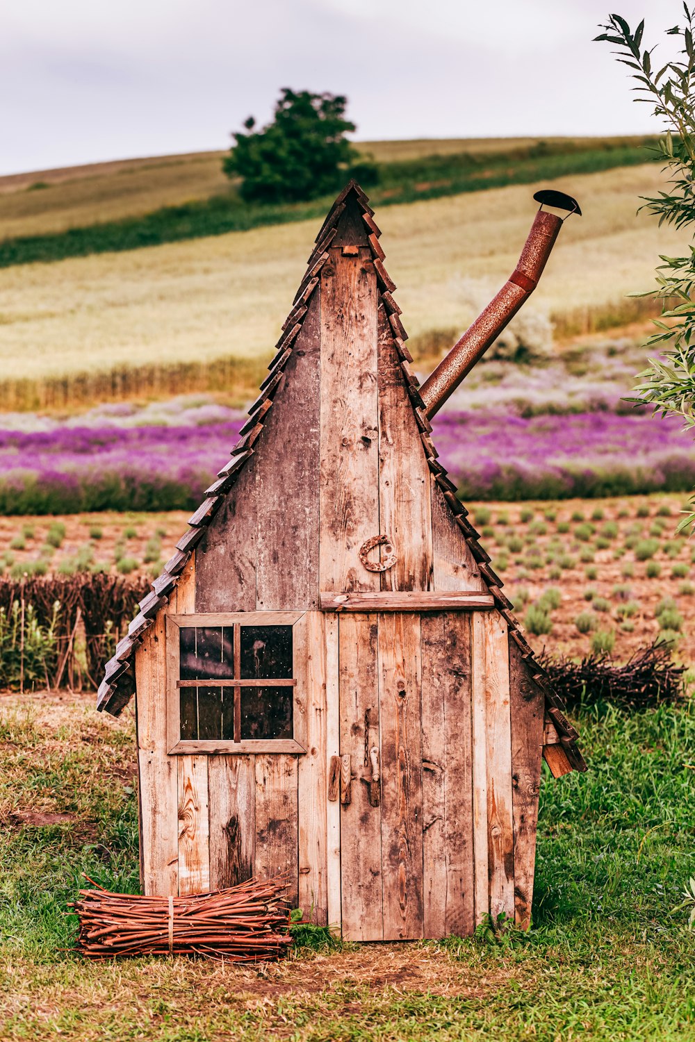 casa di legno marrone sul campo di erba verde durante il giorno