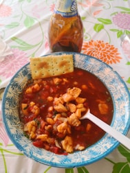 A steaming bowl of seafood soup garnished with herbs.