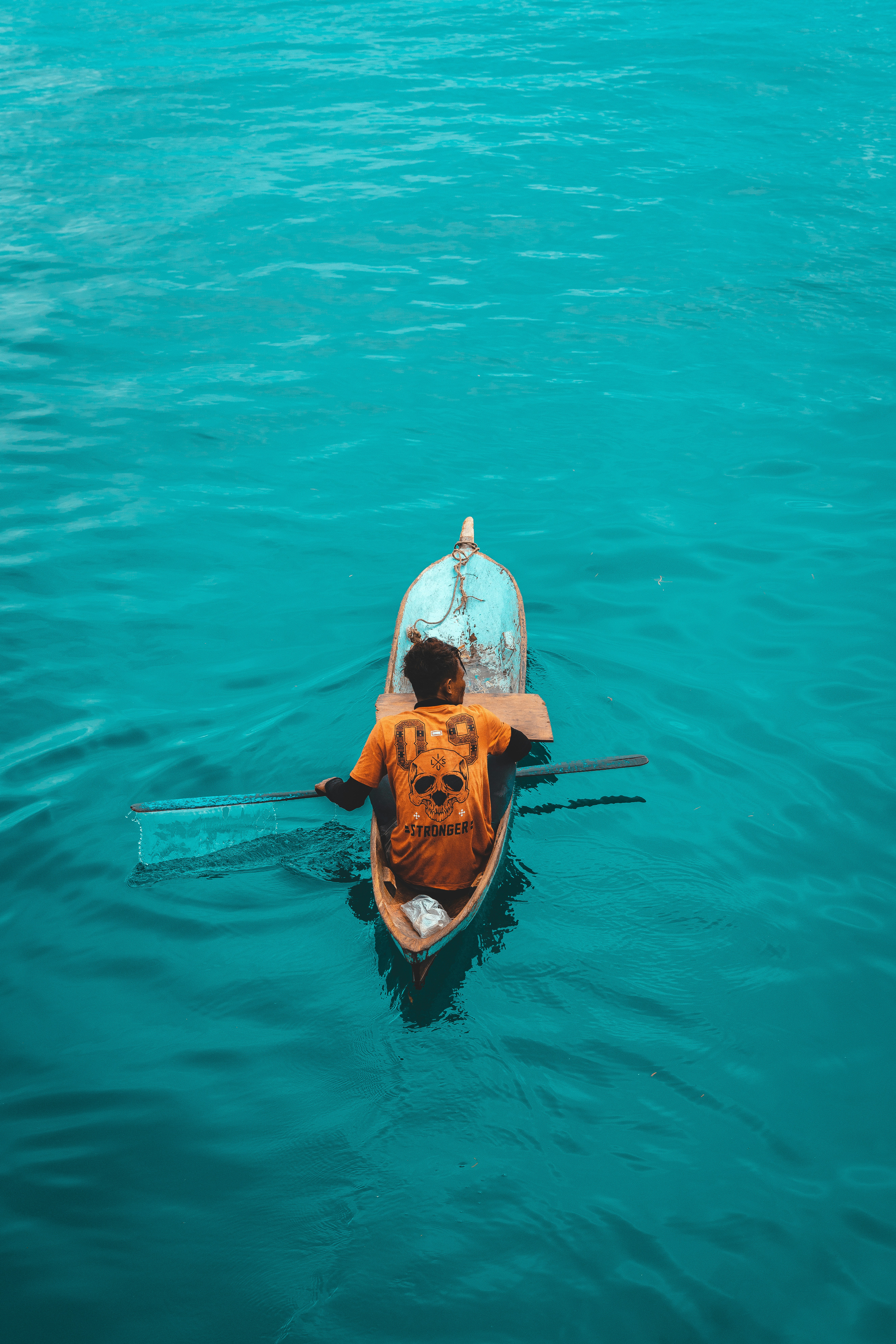 man and woman in white and brown long sleeve shirt riding on brown boat on body