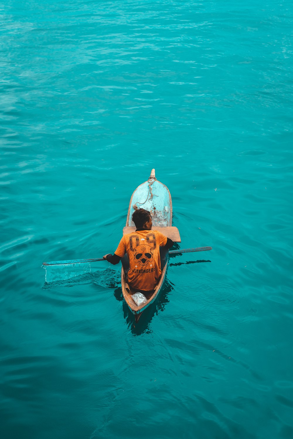 man and woman in white and brown long sleeve shirt riding on brown boat on body