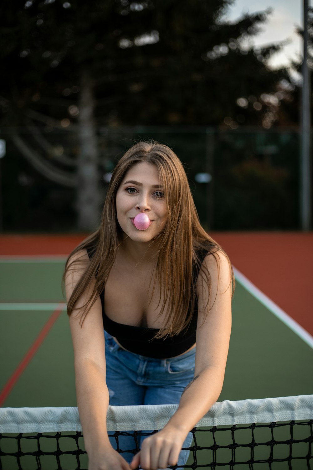 woman in black tank top and blue denim shorts standing on track field during daytime