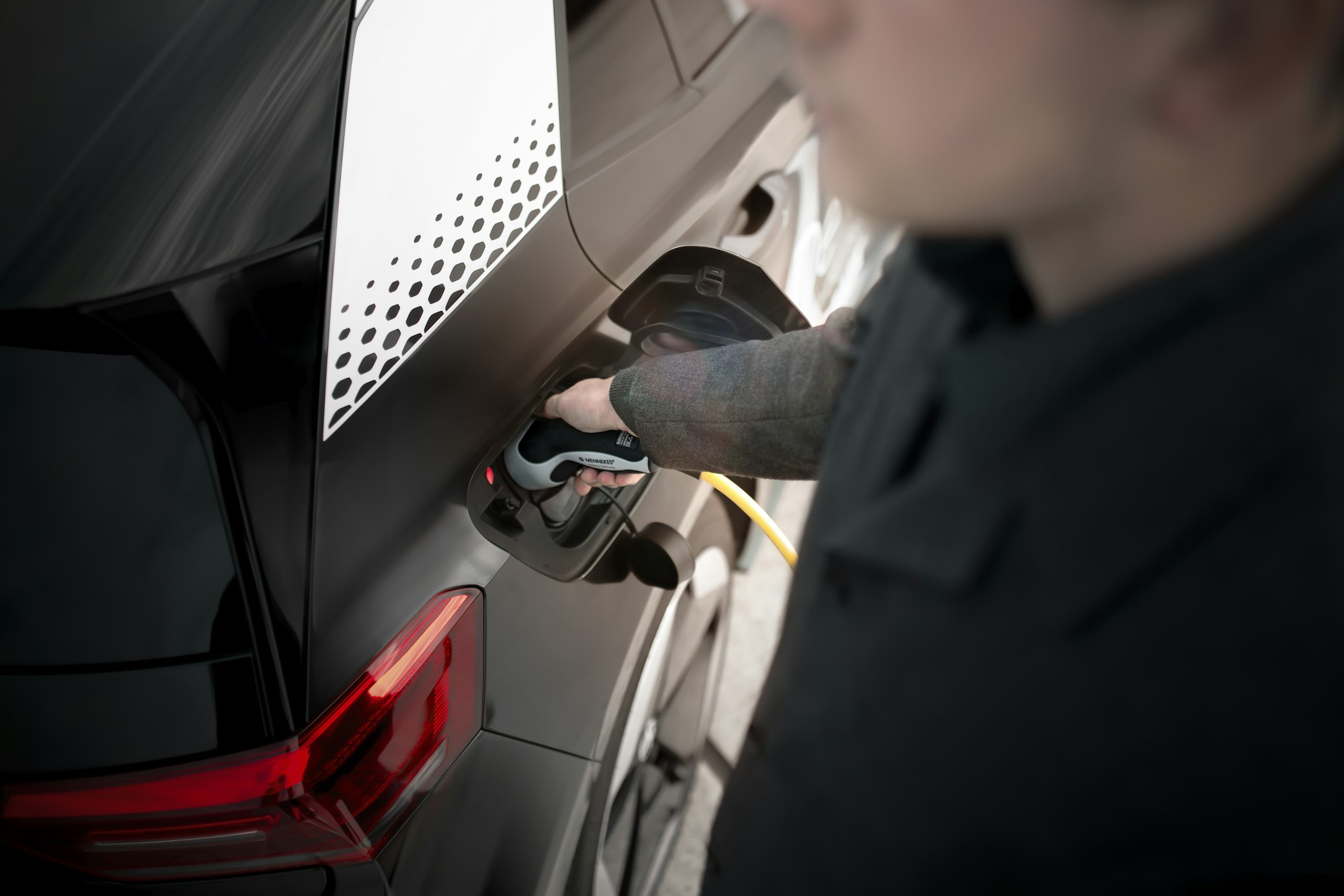 man charging electric vehicle