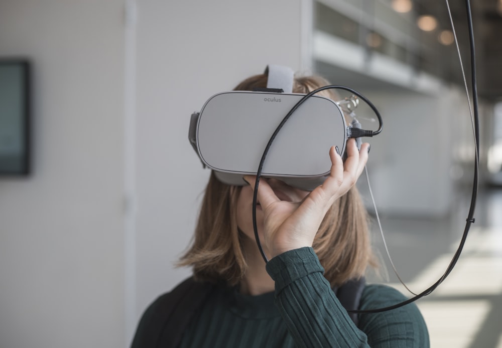 Frau in schwarzem Pullover mit weißer und schwarzer VR-Brille