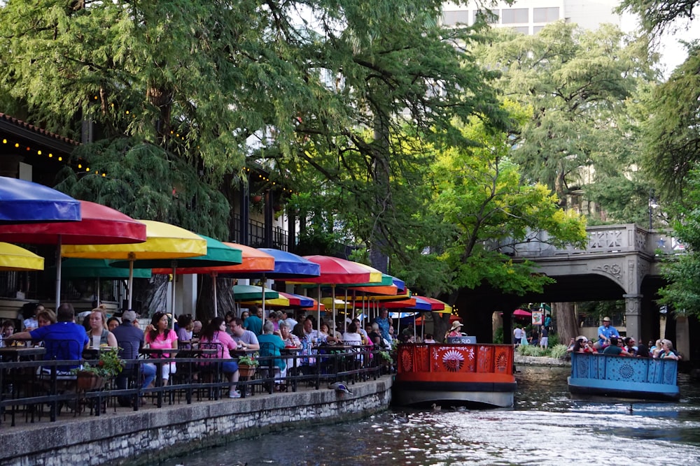 people riding on red boat on river during daytime