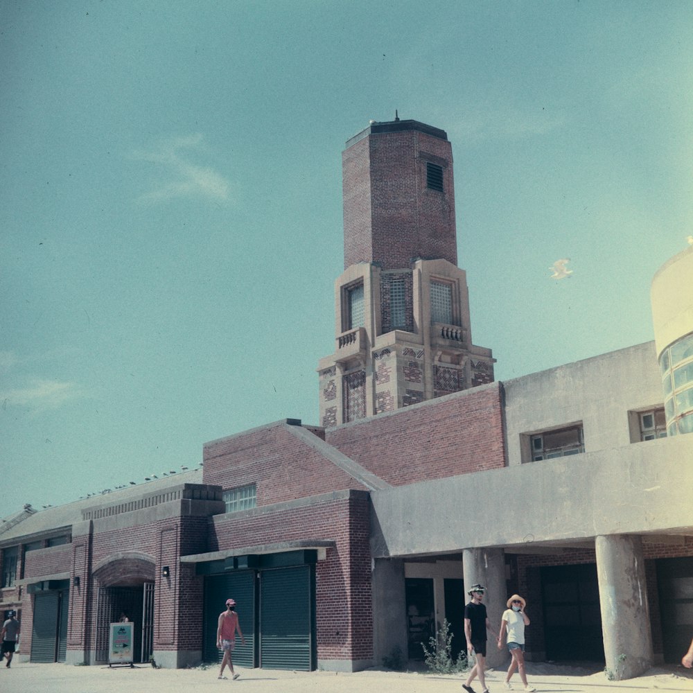 Personas de pie cerca de un edificio de hormigón marrón durante el día
