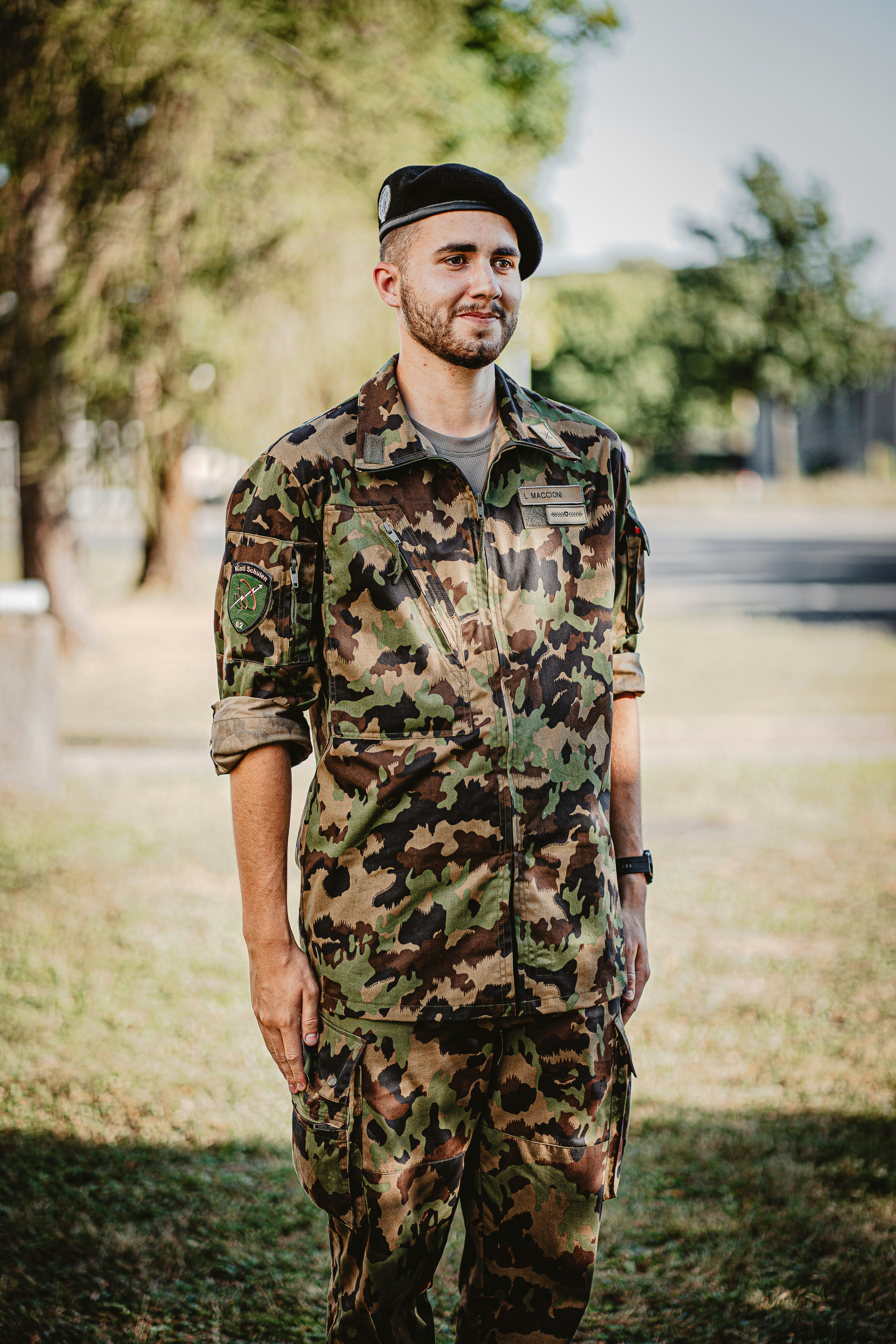 man in green and brown camouflage uniform standing on brown field during daytime