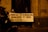 Several people are gathered in a dimly lit area holding protest signs in Spanish. The signs translate to messages that challenge tyranny and call for revolution as order. One person is wearing a face shield. There is graffiti on the wall that reads 'CONGRESO DICTADOR'. The mood suggests a political protest.