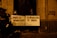 Several people are gathered in a dimly lit area holding protest signs in Spanish. The signs translate to messages that challenge tyranny and call for revolution as order. One person is wearing a face shield. There is graffiti on the wall that reads 'CONGRESO DICTADOR'. The mood suggests a political protest.