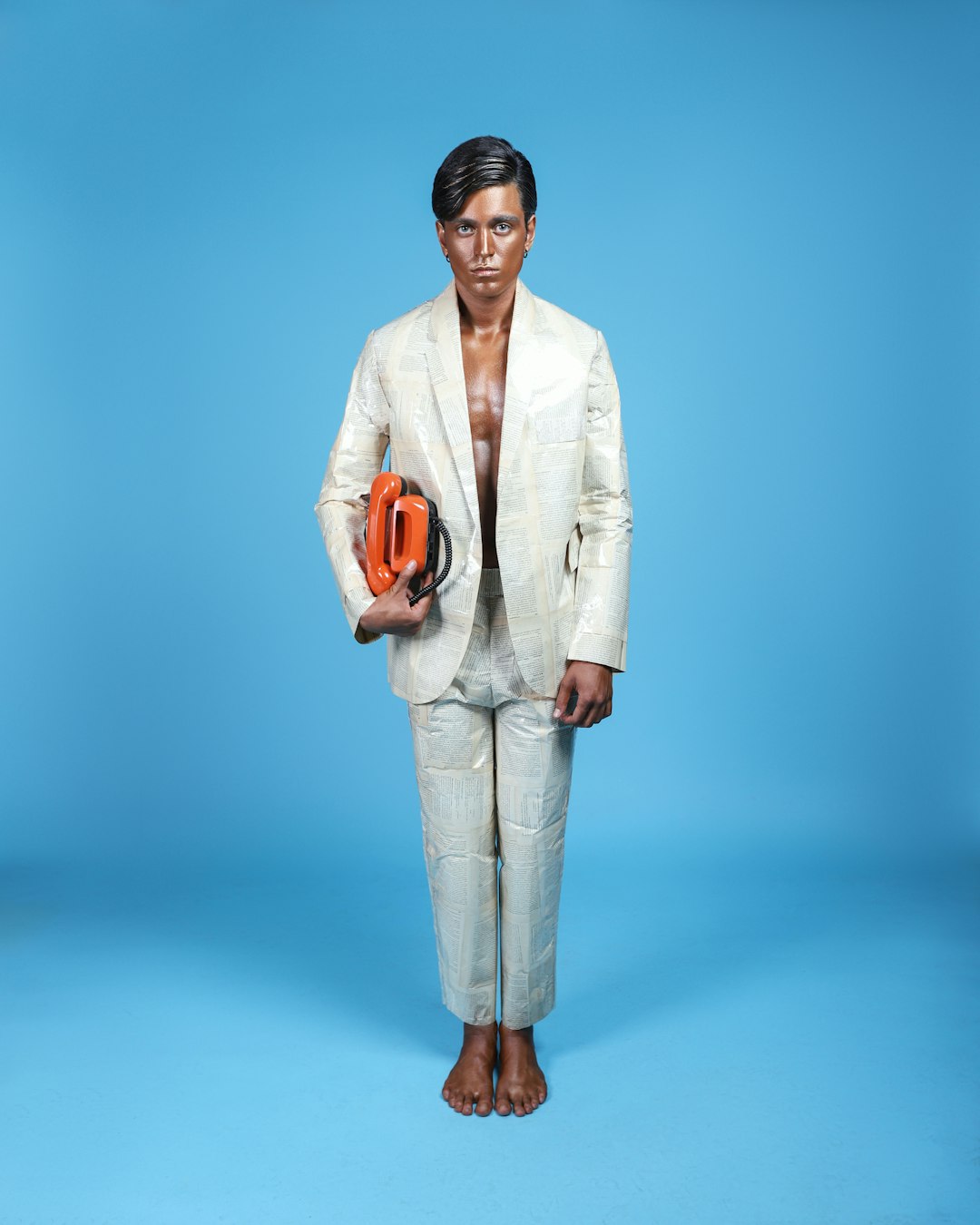 man in white suit holding orange ceramic mug