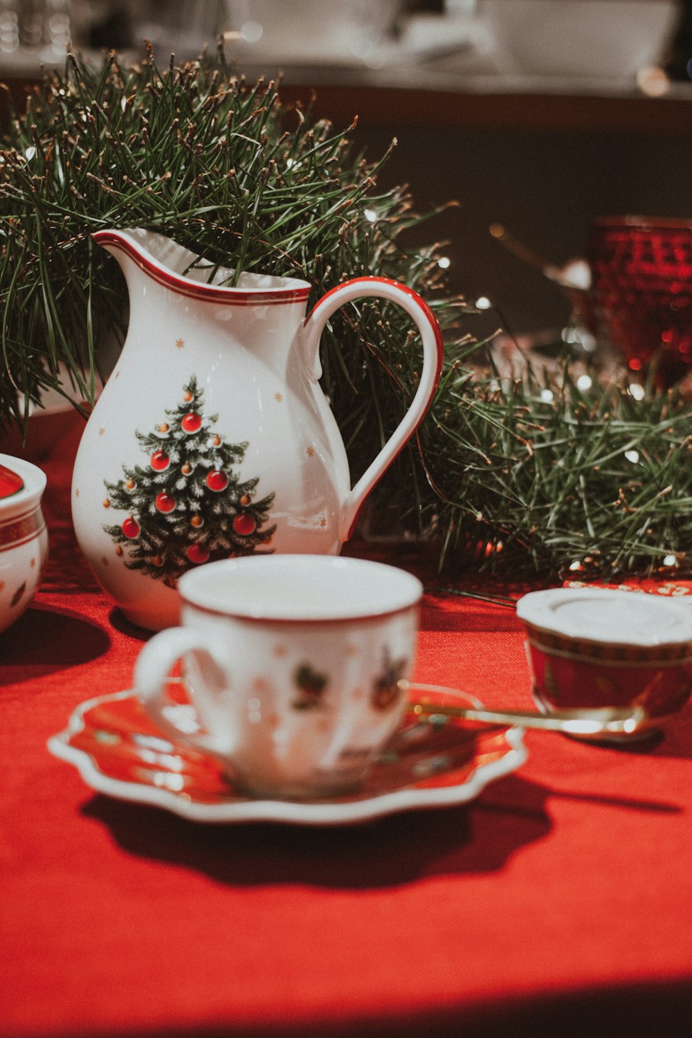 white and red floral ceramic pitcher and saucer