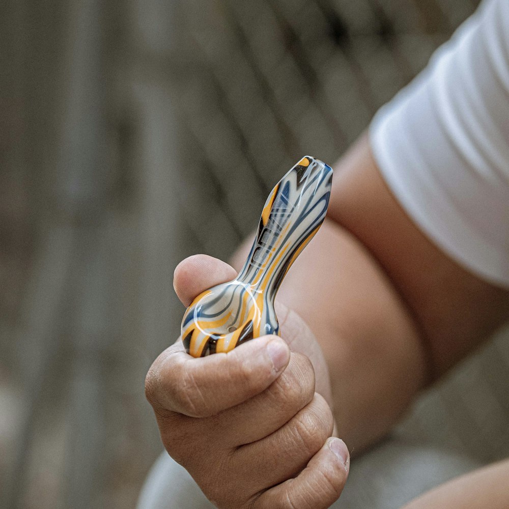 person holding yellow and black plastic toy