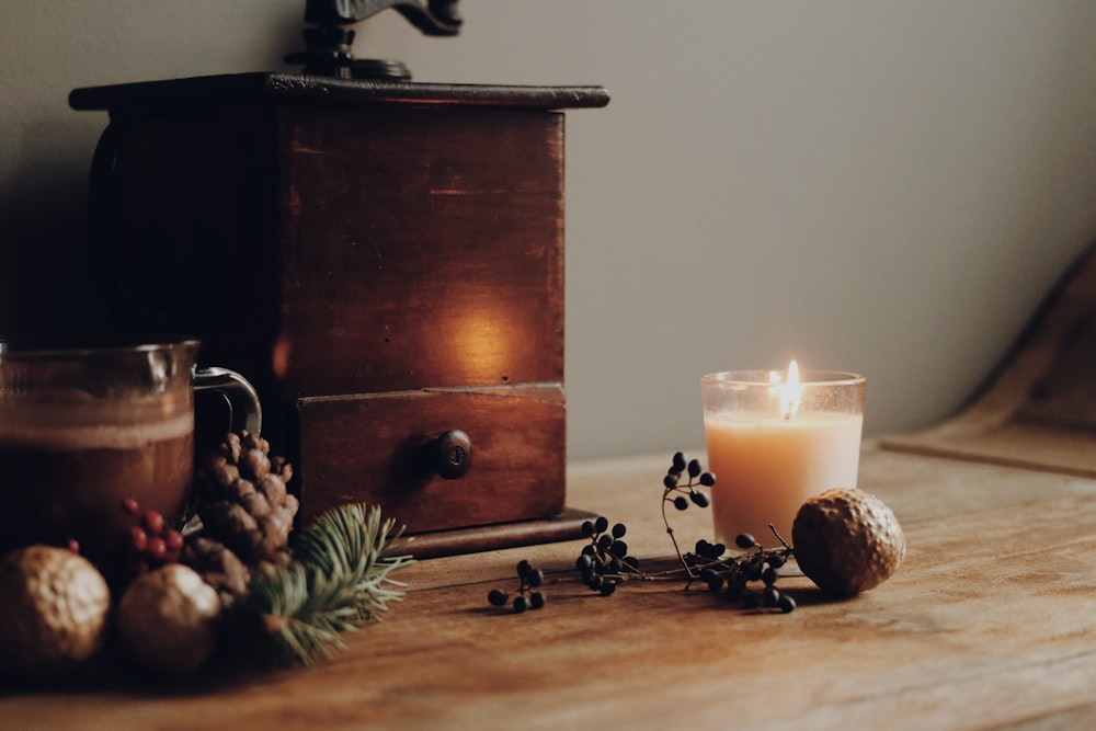 lighted candle beside brown wooden drawer