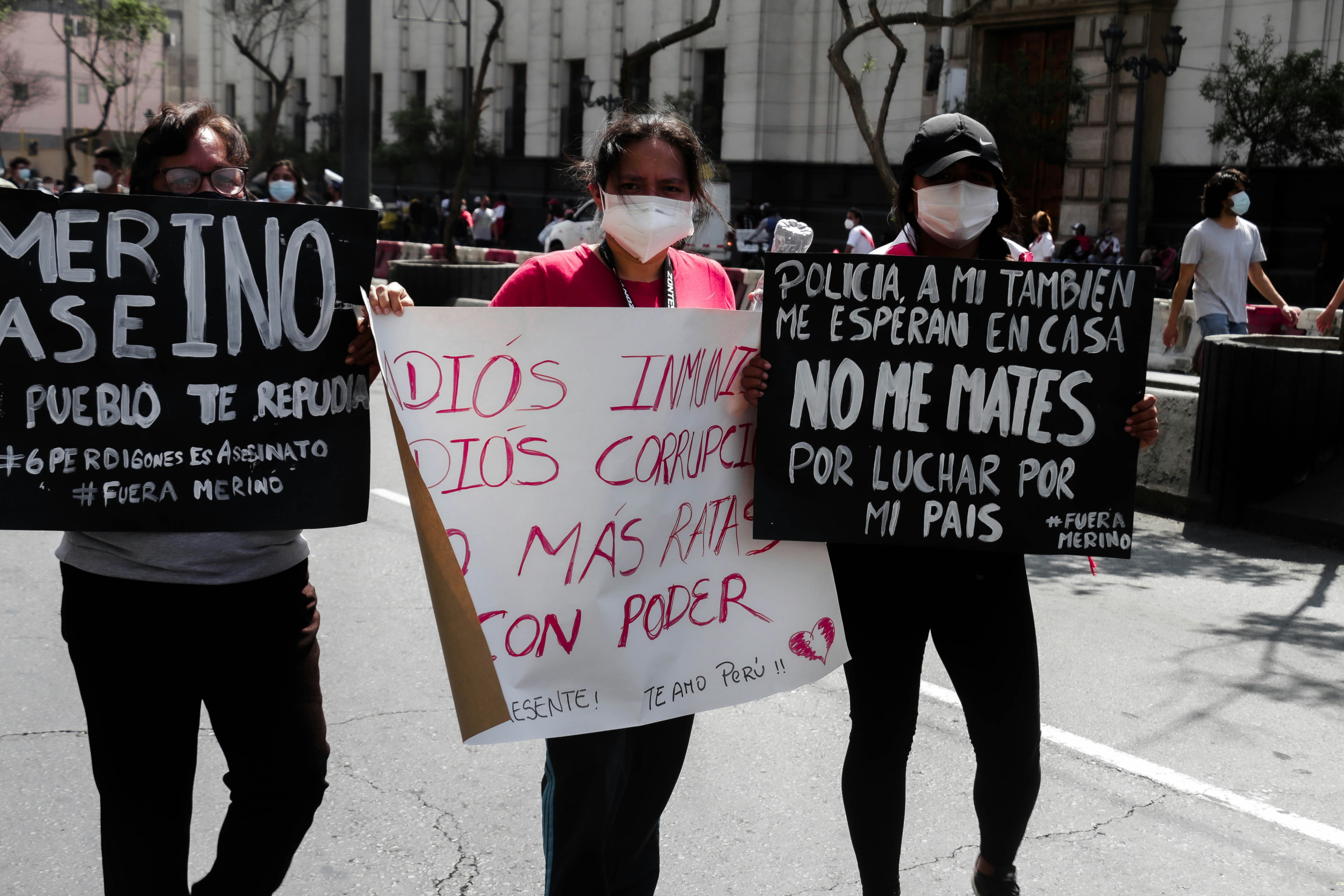 a group of people holding protest signs on a city street