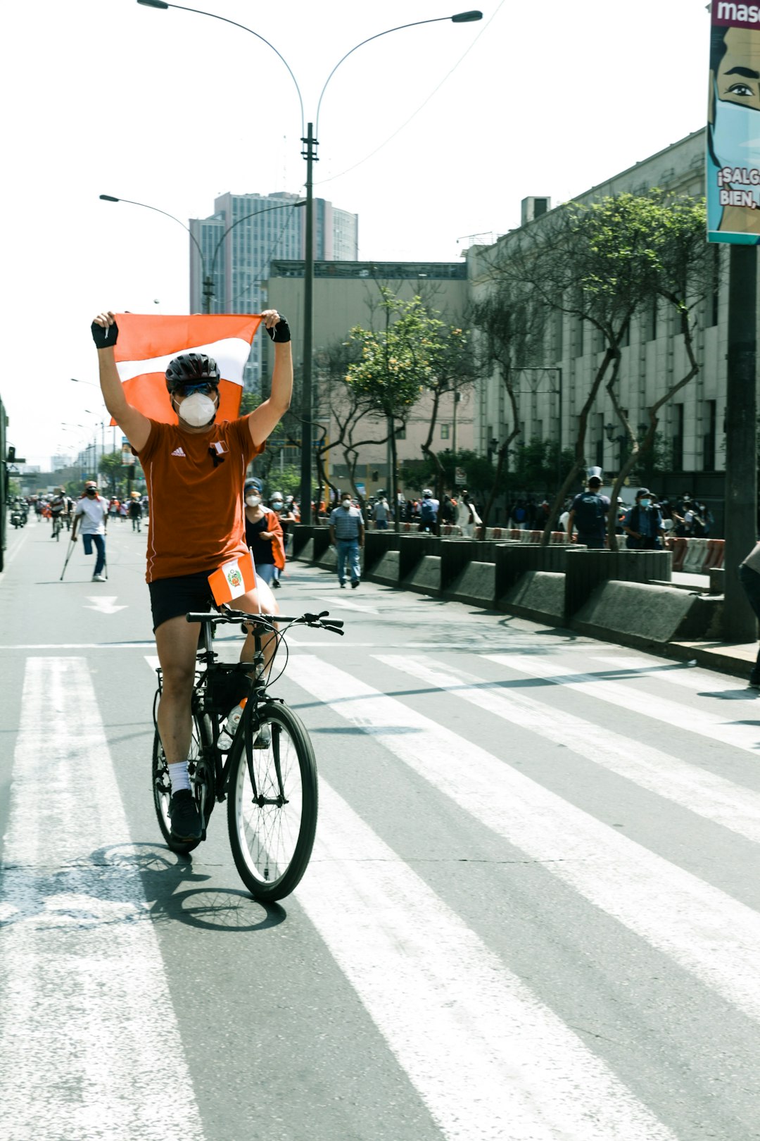 man in orange t-shirt riding bicycle on road during daytime
