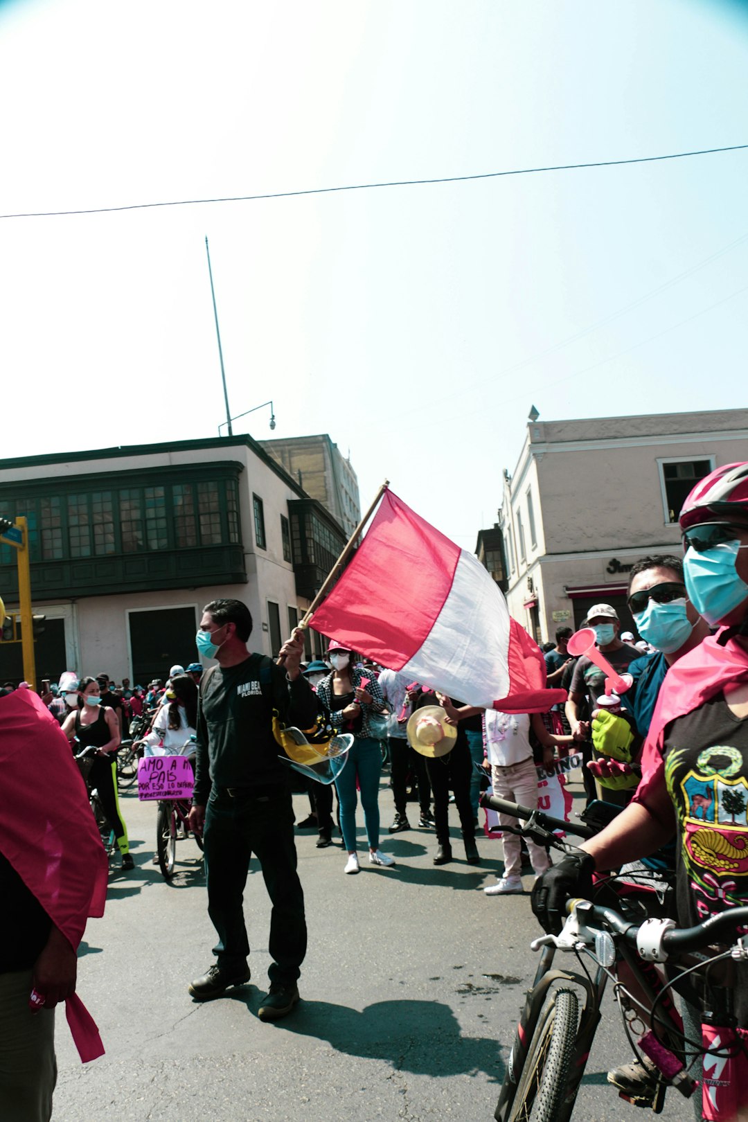 people in a street with a red and white flag during daytime
