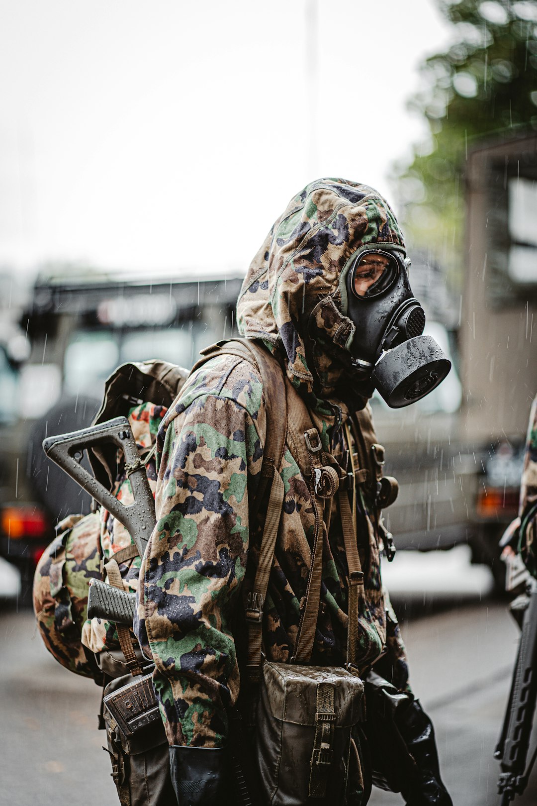 person in green and brown camouflage jacket wearing gas mask