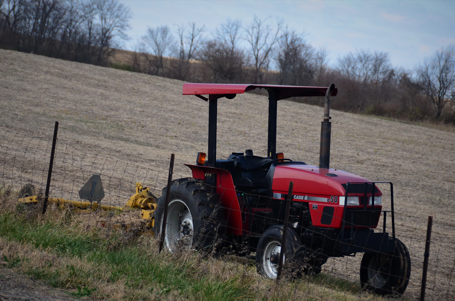 Tractor brush hogging an overgrown field