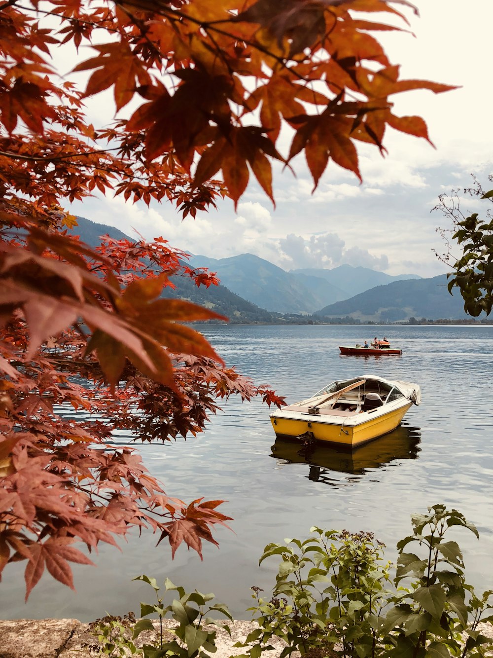 Bateau brun sur l’eau près de la montagne pendant la journée